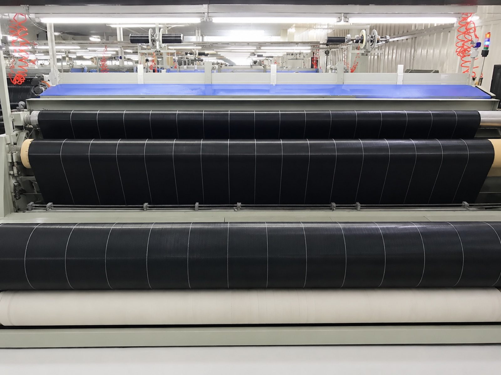 Black woven ground cover fabric running on production machine