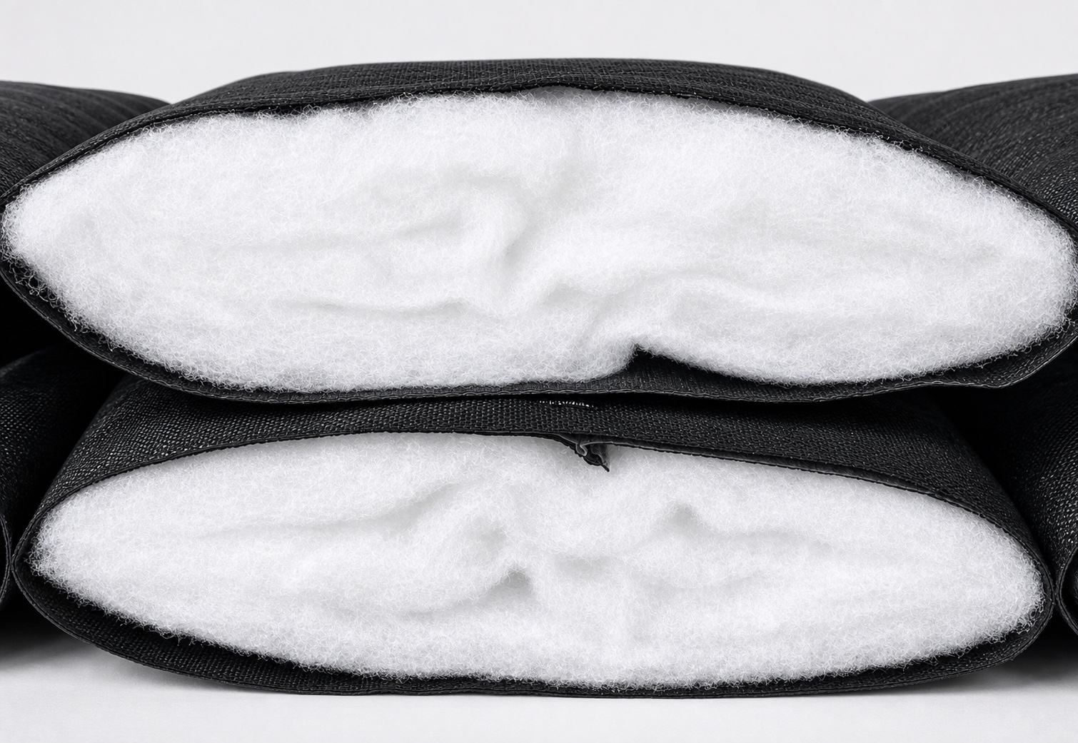 Greenhouse insulation quilt cross-section showing black PE woven shell and clean white synthetic fiber cotton core