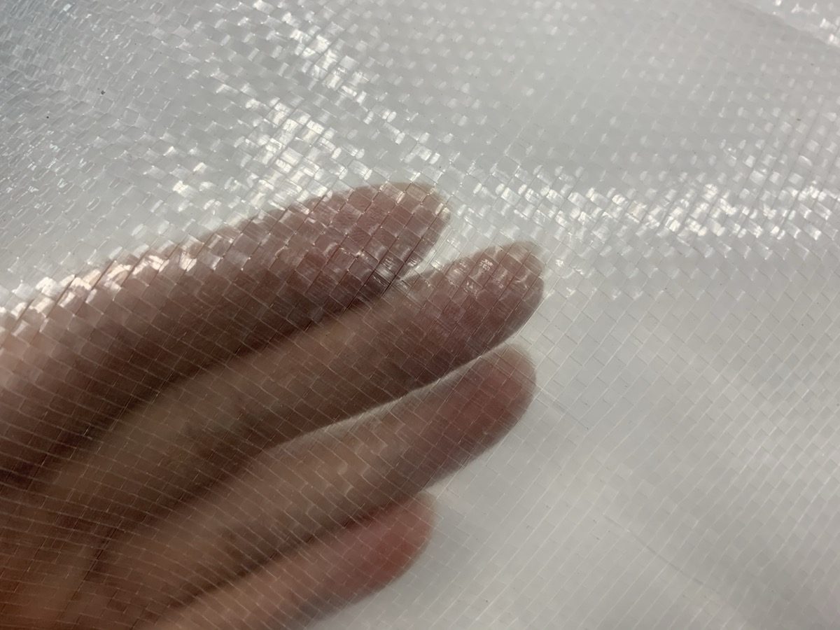 Close-up detail of reinforced PE greenhouse covering film with woven base and laminated surface