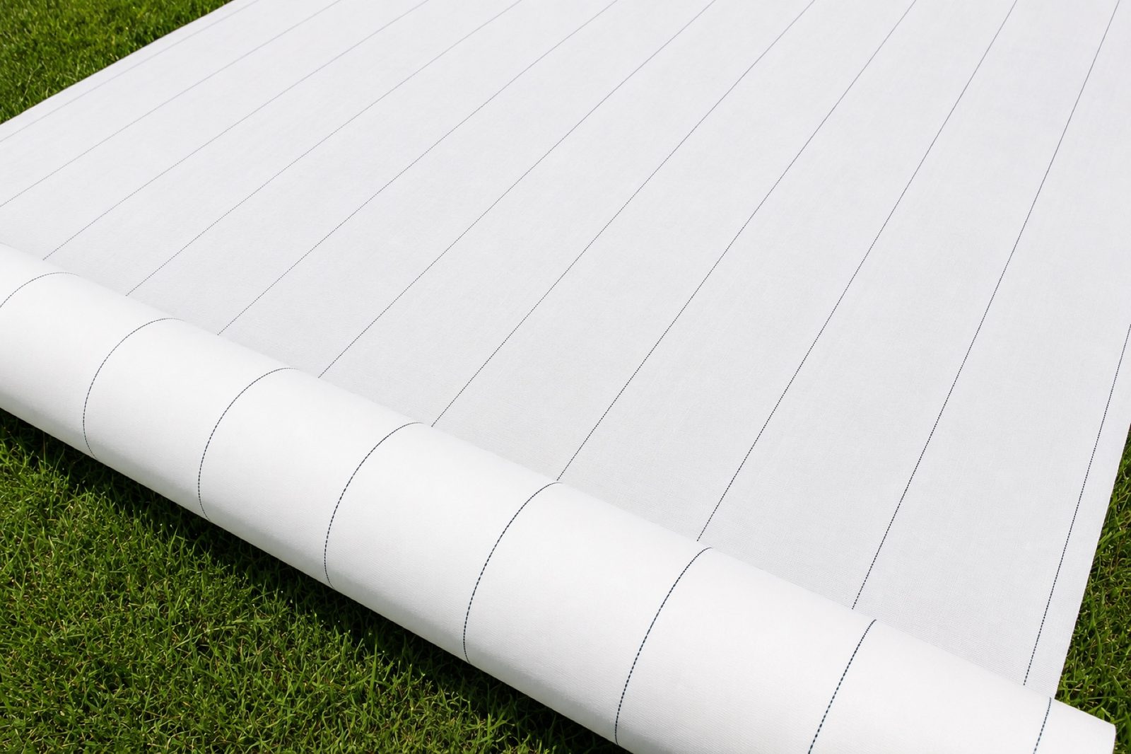 Full view of white reflective PE ground cover roll on grass